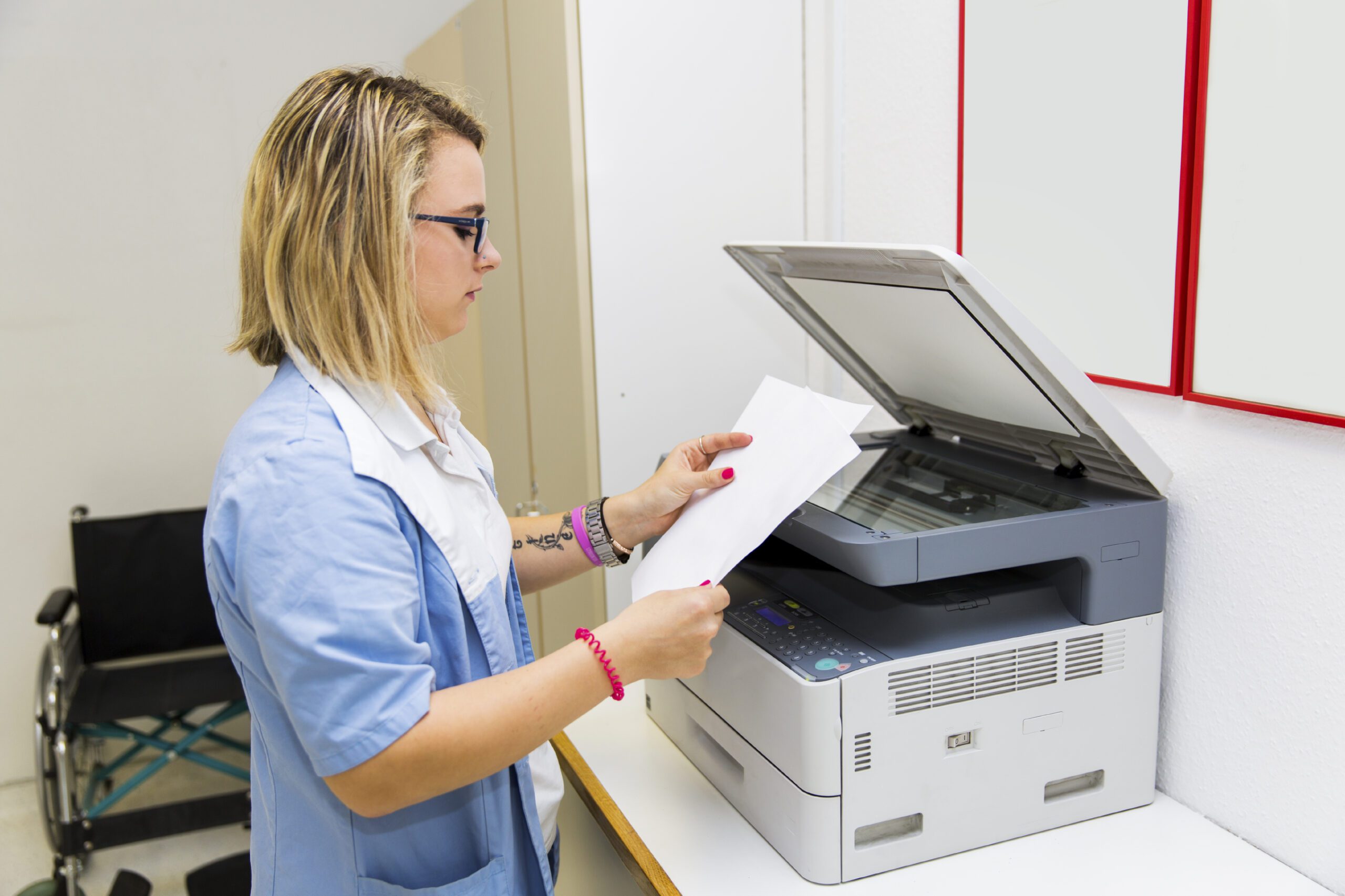Stack of clinic fax documents being sorted and triaged